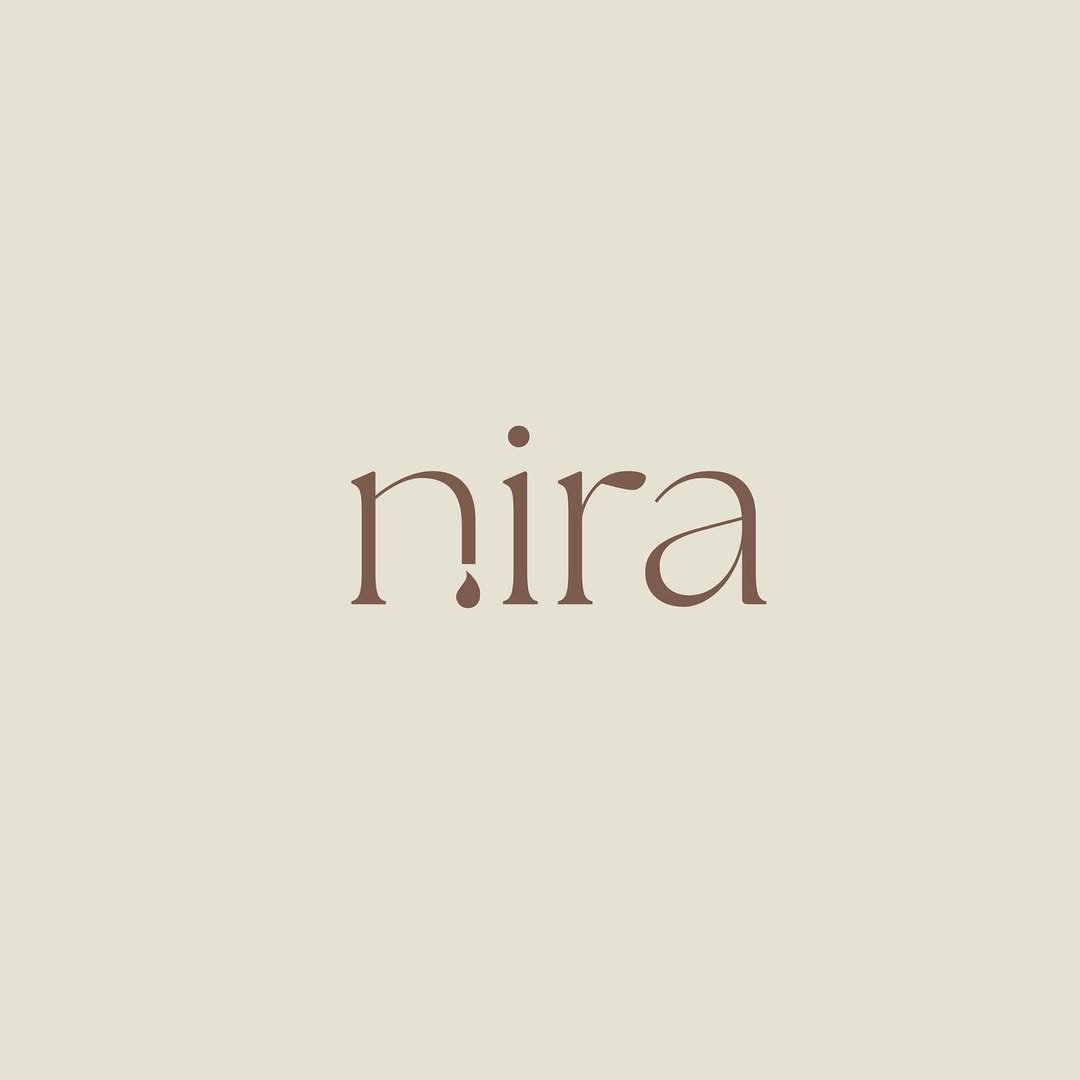 Nira wordmark on cream background — the dotless 'i' with a falling teardrop